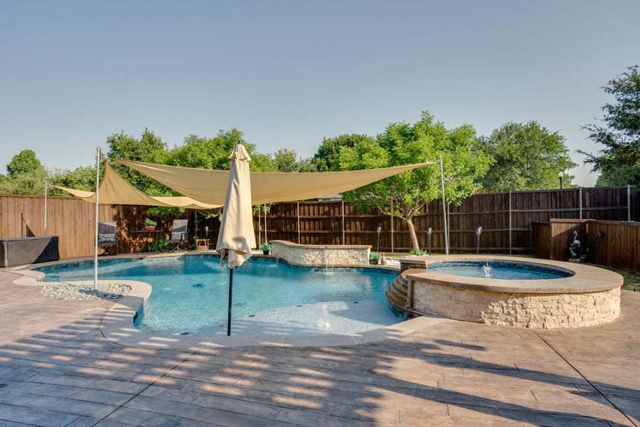 Weekly Pool Cleaning Service Flower Mound Pool Care. Swimming pools are only fun when they're clean, but it's expensive and time-consuming to do the work yourself. Image of a pool, with sun shade, and jazuzzi.