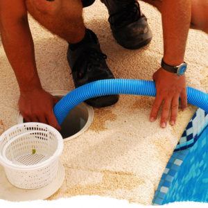 A different picture showing pool technician cleaning out pool basket.
